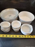 All cookware pieces arranged with tape measure for scale