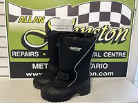 Side view of both boots showing overall condition, brand logo, drawstring top and Velcro strap