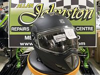 Front-left view of matte black CKX Tranz RSV modular helmet with clear visor and attached tag