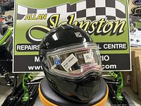 Black CKX Tranz RSV modular helmet on display stand showing visor stickers indicating size XL