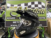 Black CKX Titan AMX helmet with Apex goggles displayed on stand