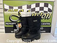 Pair of CKX Taiga boots standing side-by-side showing front and outer sides with tags attached
