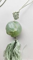 Overall view of jade ball pendant on silk cord with tassel