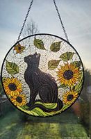 Full view of round stained glass panel hanging in window