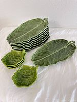Stacked view of eight banana leaf plates and four small leaf bowls