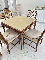 Square faux bamboo table with beige vinyl top and four matching chairs