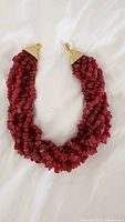 Full view of twisted multi-strand red chip bead necklace with clasp