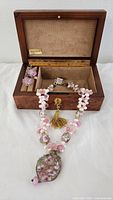 Necklace, earrings, and open burl wood jewelry box displayed together