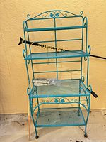 Front view of turquoise 3-tier metal mesh shelf