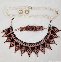 Lot overview showing beaded collar necklace, matching bracelet, twisted pearl necklace, and pair of faux pearl clip-on earrings