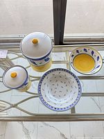 Top view of both canisters with lids, large serving bowl, stack of small bowls
