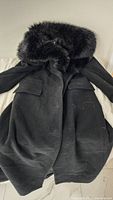 Full front view of black Zara long coat with faux fur collar