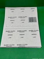 Stack of emery cloth sheets showing backing print and barcode