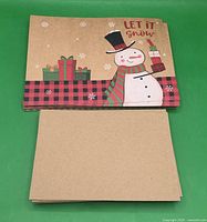 Stack of snowman design cards and stack of blank kraft envelopes