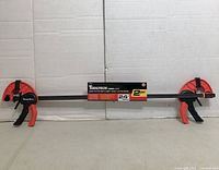 Full view of one 24" Tooltech bar clamp showing overall design and attached product sleeve