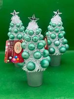 Group of three matching tinsel tabletop Christmas trees