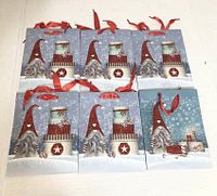 Six identical holiday gnome gift bags laid flat showing full front design