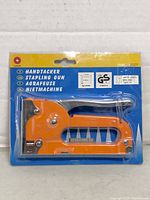 Front view of sealed LeMORE stapling gun in package