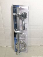 Front view of sealed StreamWay handheld shower head kit showing shower head, slide bar, hose in packaging