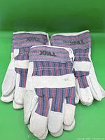 Three pairs of grey leather work gloves stacked