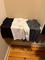 All three shirts folded on shelf showing colors and Duke logos