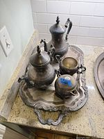 Top view of full six-piece set on tray showing tarnish and ornate design