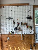 Wide view of pegboard with clustered screwdrivers, nut drivers, hex key set and picks