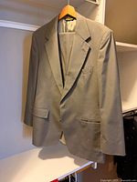 Front view of jacket and trousers on hanger