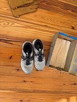 Pair of shoes next to open Brooks shipping box overview