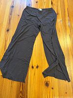 Full view of black wide-leg pajama pants laid flat