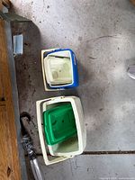 Top view of two hard plastic coolers open, showing interiors and lids