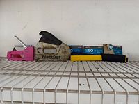 All three staple guns and staple boxes on shelf