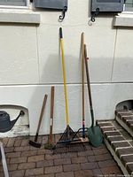 All five garden tools leaned against wall
