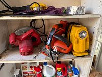 Front view of circular saw, jigsaw, work light and tarps on shelf