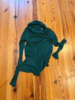 Full view of green long-sleeve cowl neck top laid flat