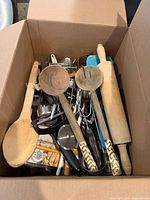Top view of box showing majority of utensils, wooden rolling pin, spoons and felt pads package visible