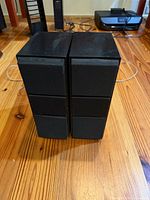 Front view of both black bookshelf speakers showing grille design and cabinet shape