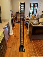 Full view of tall black slotted media tower standing on kitchen floor