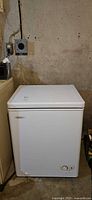 Front view of white Danby chest freezer showing control knob and overall condition