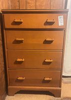 front view of four-drawer dresser showing pulls and wood finish