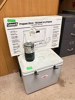 Overall lot showing stove box, propane cylinder, Koolatron cooler