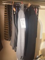 Grey jacket and black overcoat on hangers