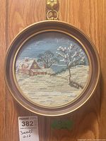 Front view of round needlepoint in frame