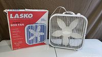 Fan positioned beside its original box