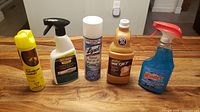 Five cleaning supplies lined up on counter