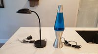 LED desk lamp and blue lava lamp side by side showing cords and adapters