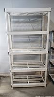 Front view of entire 5-tier white plastic shelving unit