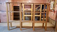 Front view of assembled open-frame wooden shelving showing lumber and plywood shelves