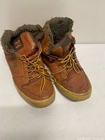 Pair of brown DC high-top boots showing fronts and fleece lining