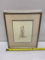 Framed artwork with mat and measurement tape showing width